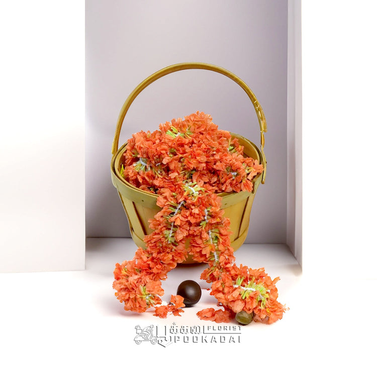 Bright orange Kanakambaram (Crossandra) flower strings mixed with white jasmine for hair.