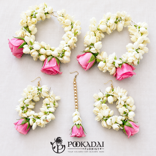 Five-piece pink rose and white floral jewellery set with two hand gajras, two hoop earrings and one maang tikka.